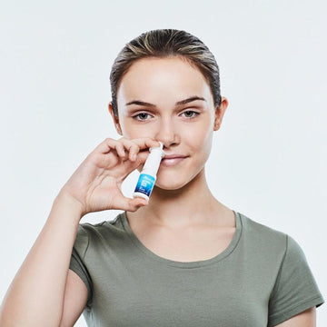 Woman applying Viraleze nasal spray to her nose