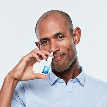 Man applying Viraleze nasal spray to nose